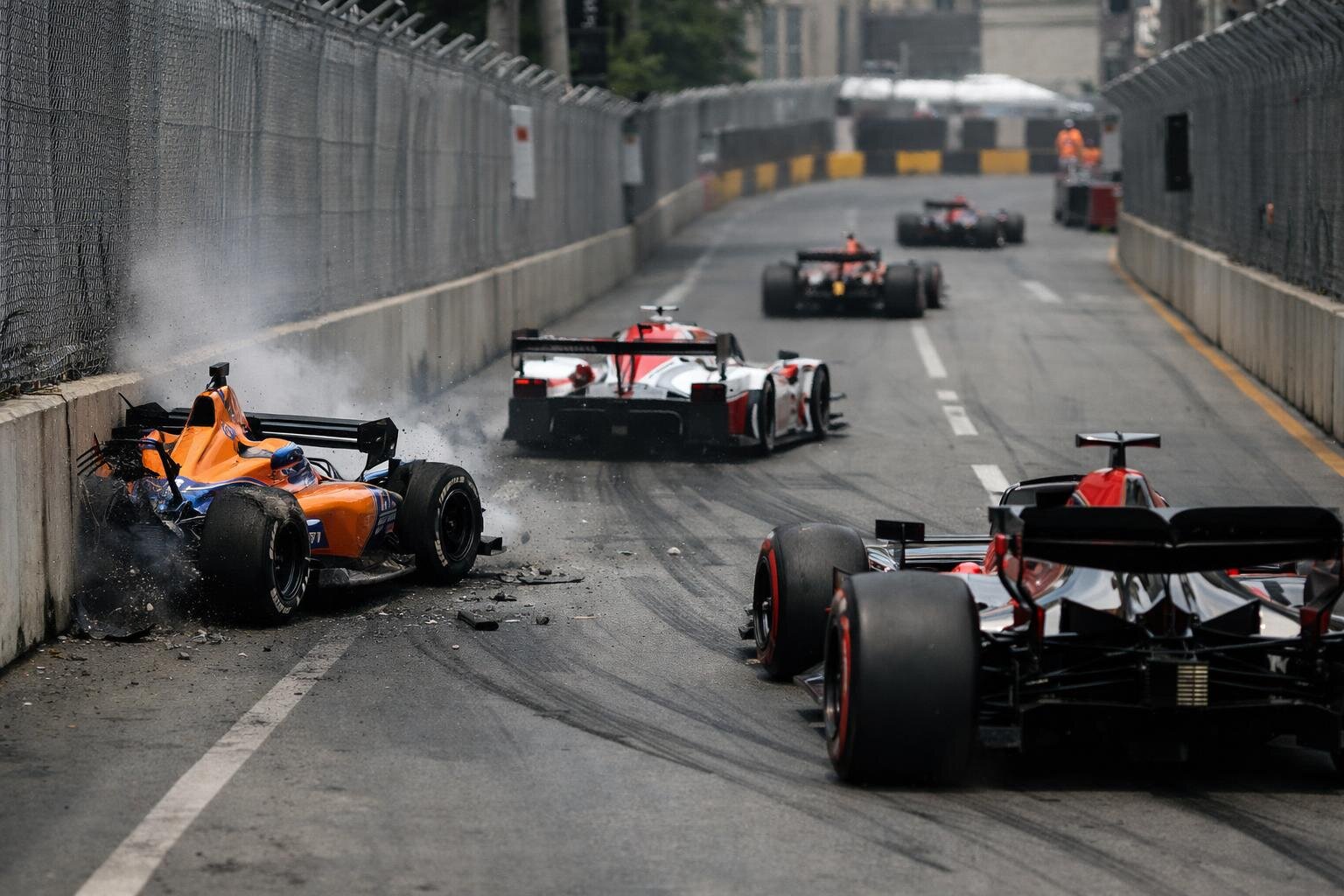 Why Street-Course Racing Produces More Cautions: The Physics of Walls, Restarts, and Narrow Exits (IndyCar/IMSA/F1)